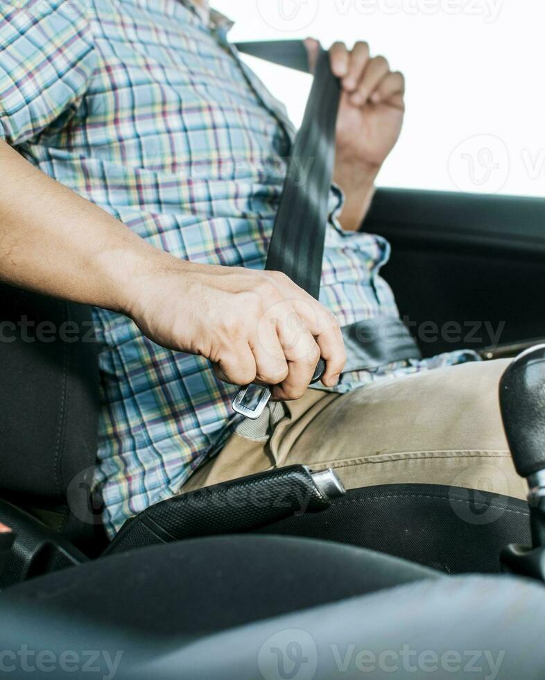 Driver hands fastening the seat belt, Close up of person hands putting on the seat belt. Driver's hands putting on the seat belt. Safety belt for accident prevention photo
