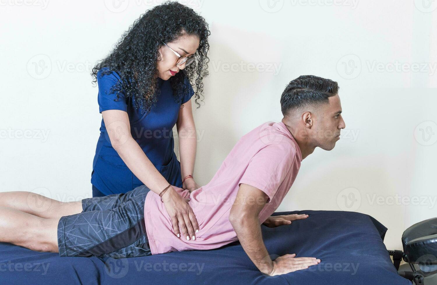 Physiotherapist performing lumbar physiotherapy to patient, Physiotherapist with patient performing lumbar treatment, lumbar physiotherapy concept photo