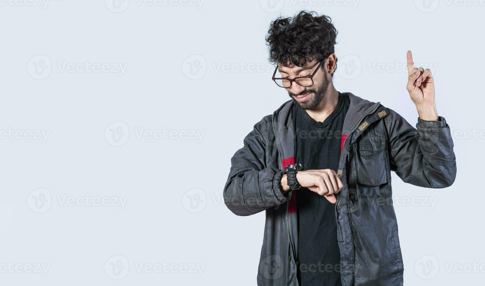 Isolated person looking at his watch and raising his finger, A man measuring time with a hand watch, Handsome man looking at the time and raising his finger photo