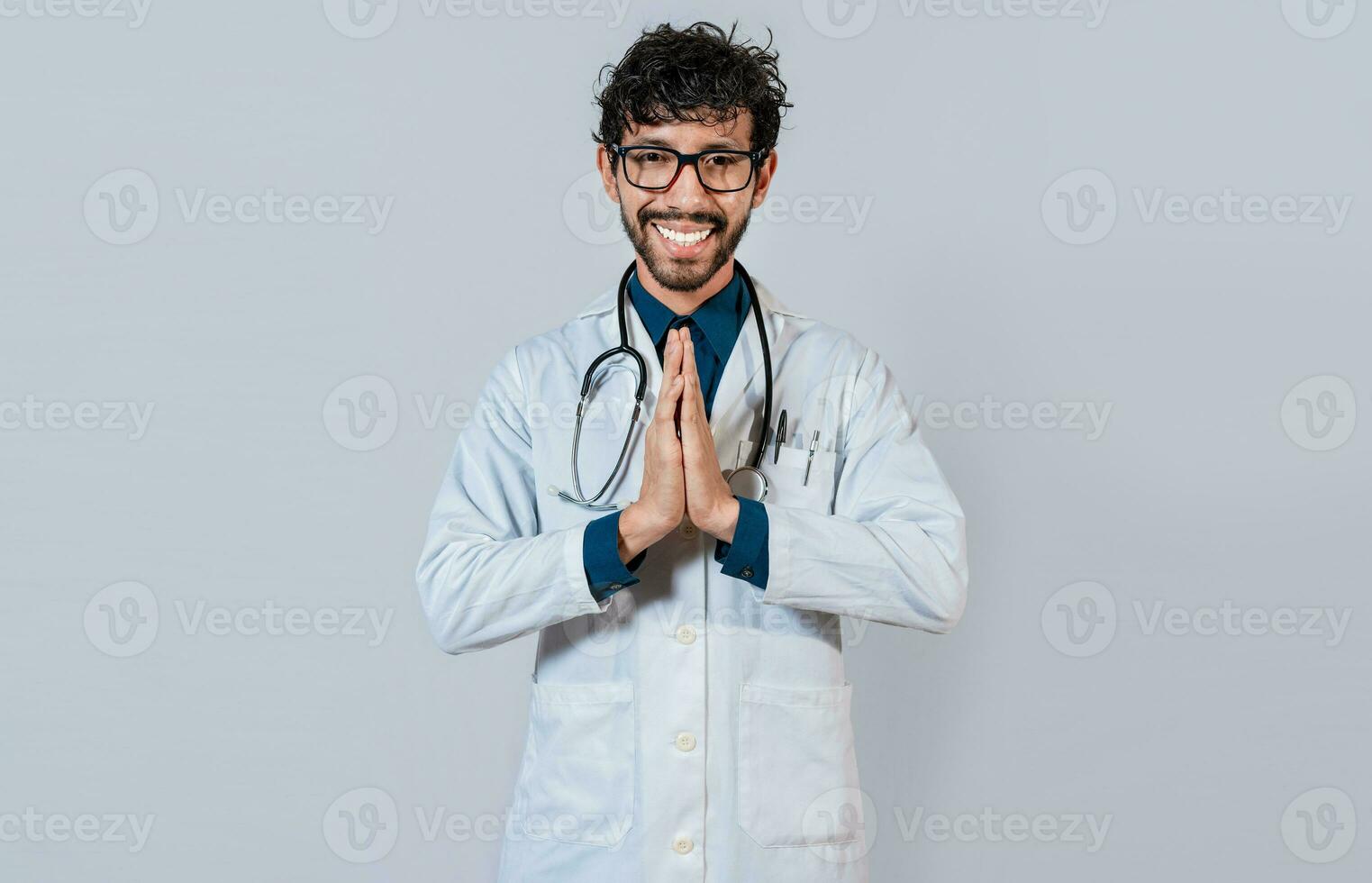 joven médico con palmas juntos. sonriente médico poniendo palmas juntos en aislado antecedentes. hermoso médico con manos juntos aislado. foto