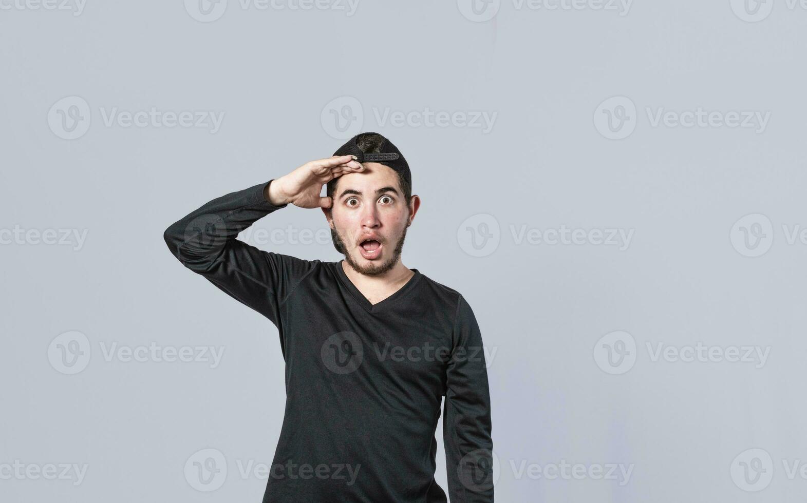 Amazed young man with his mouth open with his hand on his forehead, surprised guy with his mouth open with his hand on his forehead, concept of someone astonished photo