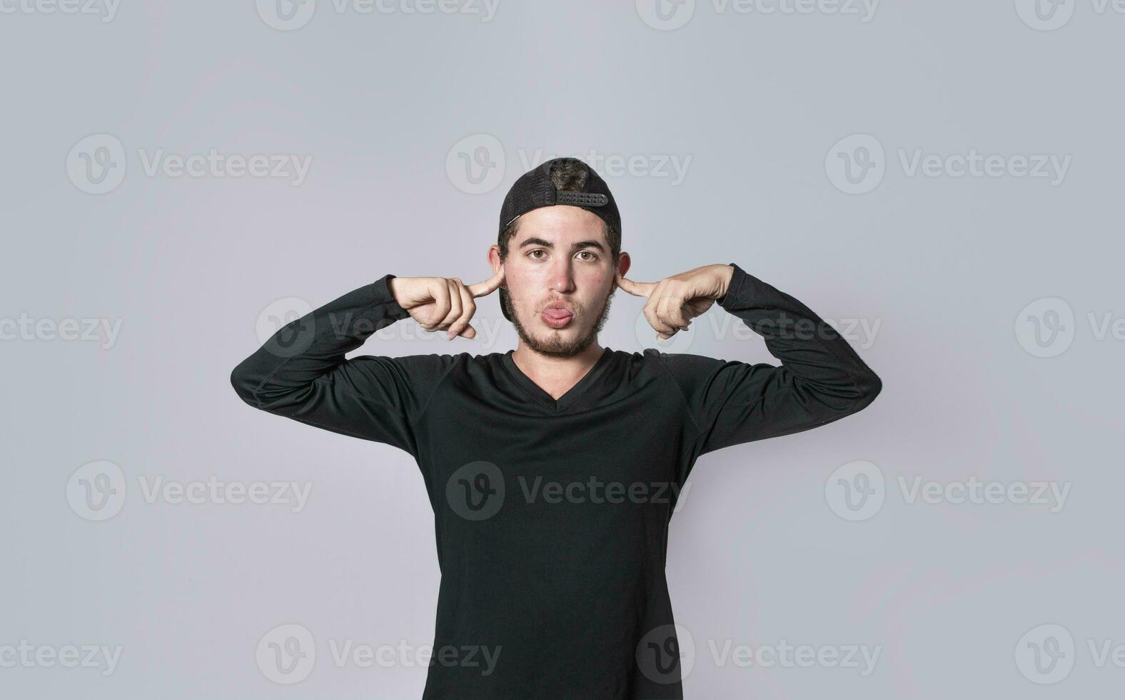 Man covering his ears isolated, guy covering his ears on isolated background, man with hands on his ears and making fun, man ignoring problems photo