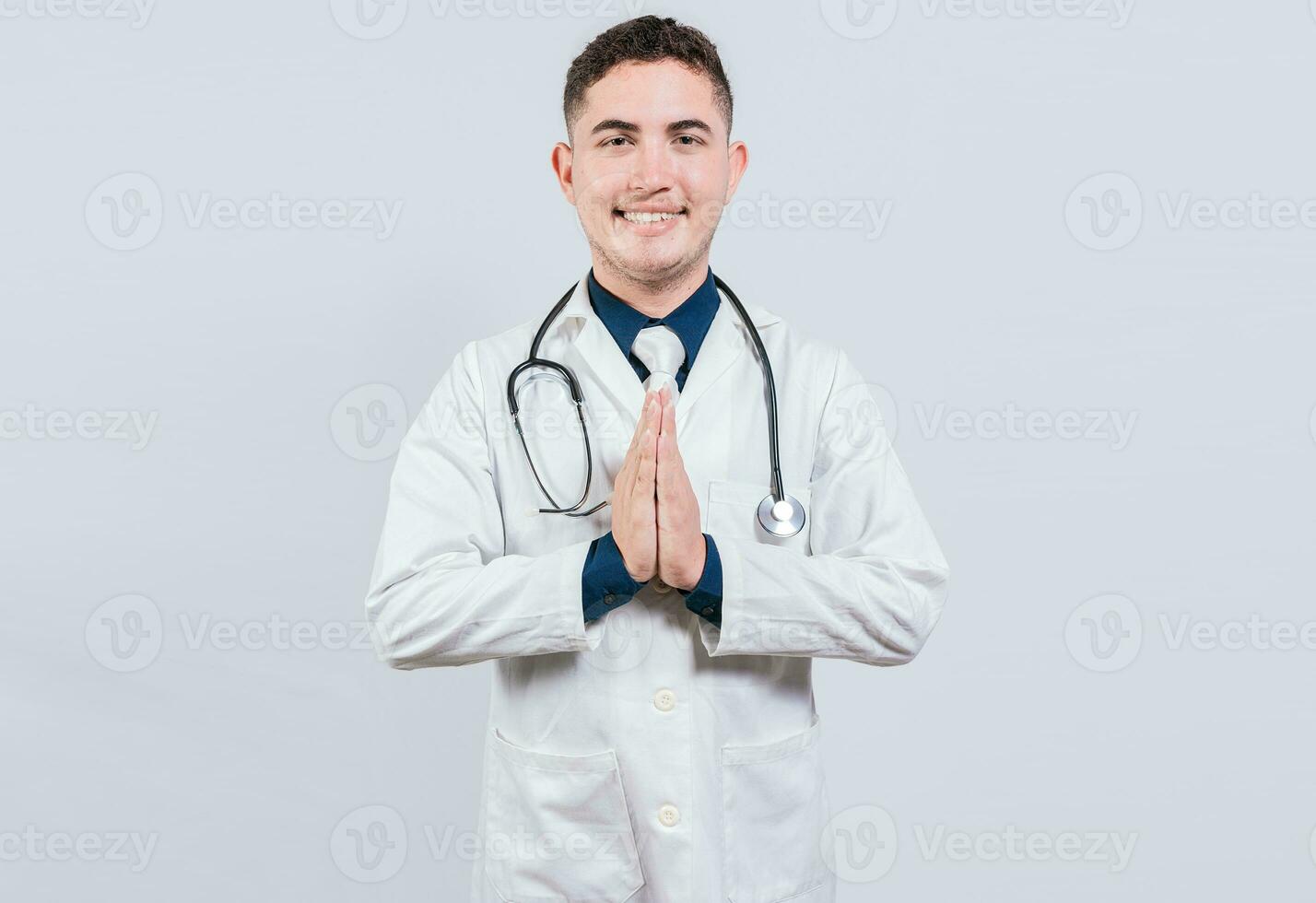 sonriente latín médico con palmas juntos aislado. alegre médico poniendo palmas juntos. hermoso médico con manos juntos aislado foto
