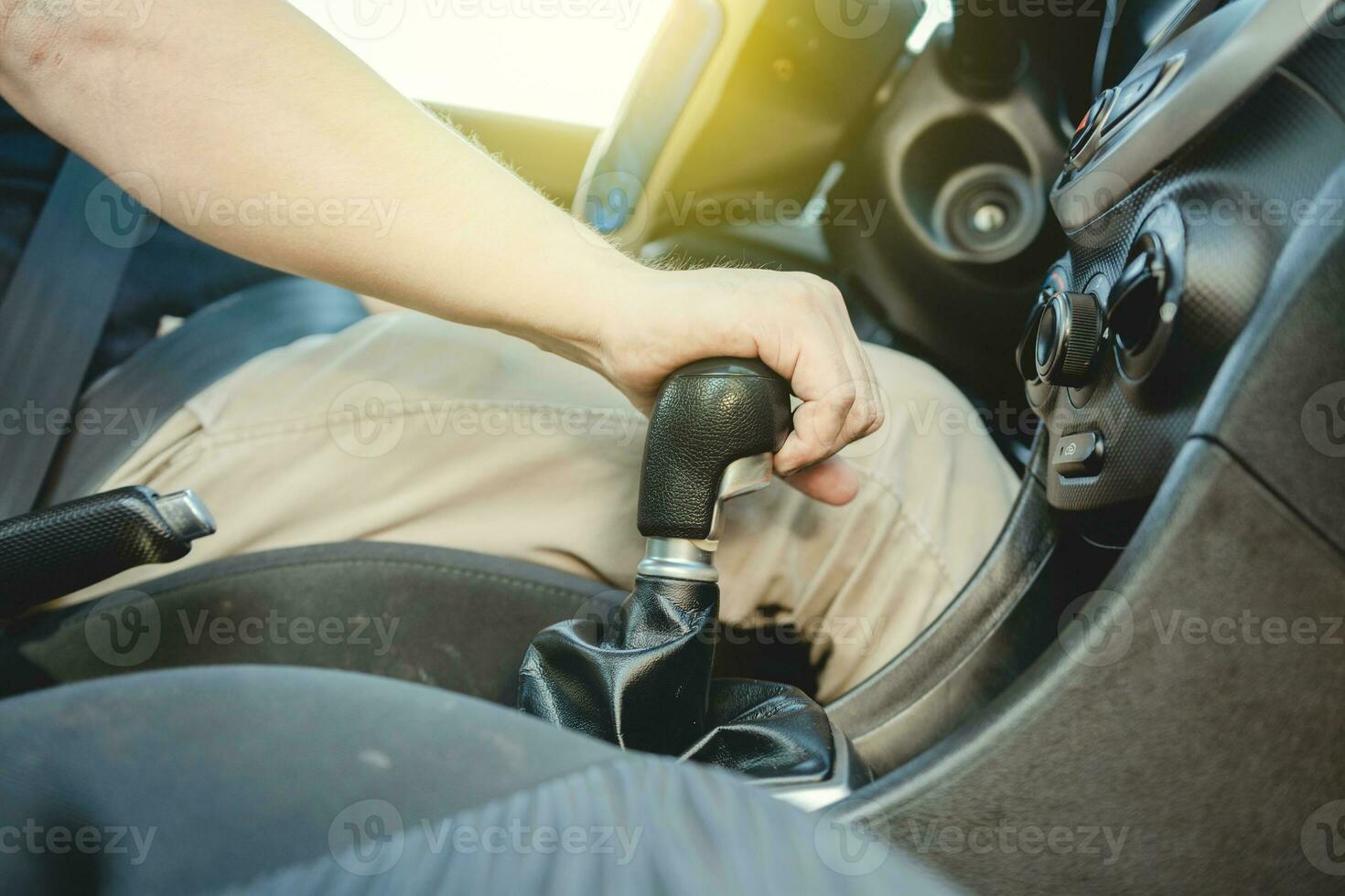 Close-up of driver hand on the gear lever of a car, Driver hand grabbing car gear stick, closeup of hands accelerating on gear stick photo