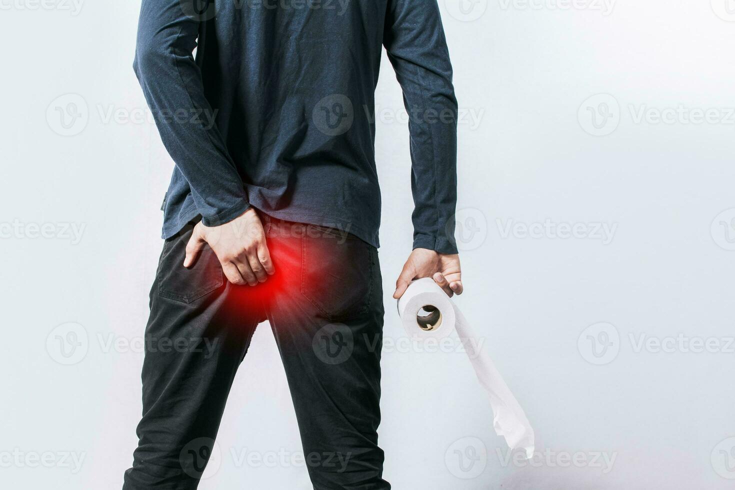 Man with diarrhea problem, man with toilet paper in hand touching his buttock, man with hemorrhoid problem on isolated background photo