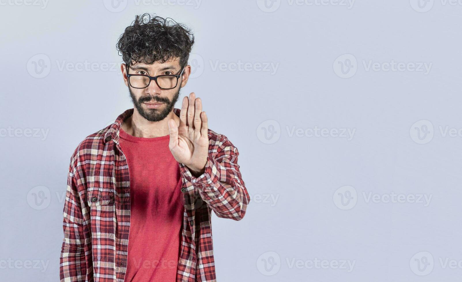 Portrait of handsome man making stop gesture with his palm. Serious man making stop sign with his palm. concept of person doing stop on isolated white background photo