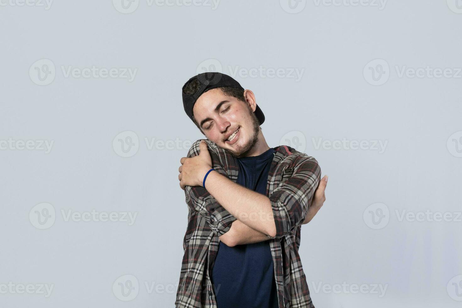 Friendly man hugging himself, Pleased young man hugging himself, Attractive positive looking friendly young man with a sincere smile embracing himself gratefully photo