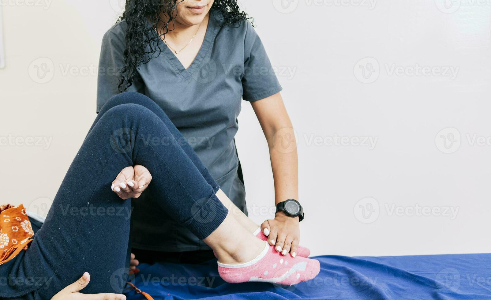 Professional physiotherapist assisting patient in leg rehabilitation, Modern leg rehabilitation physiotherapy, Worker in modern physiotherapy assisting female patient photo