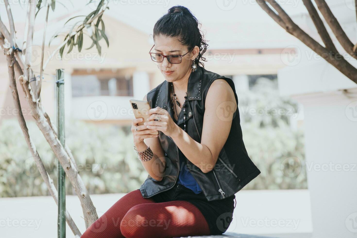 A girl checking her smartphone, urban girl sitting checking her cellphone, young woman messaging with her phone, girl holding cellphone photo