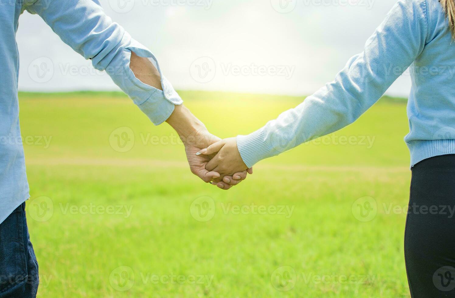 Hands together of a couple in the field, Close up of a couple holding hands, Concept of couple hands holding hands photo