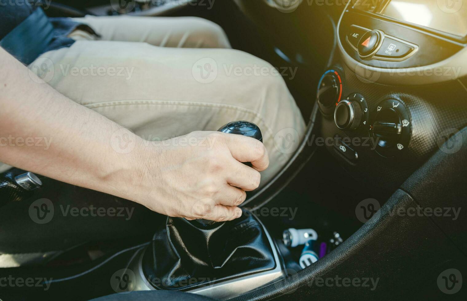 Close up of hand accelerating on gear stick. Close-up of driver hand on the gear lever of a car, Driver hand grabbing car gear stick photo