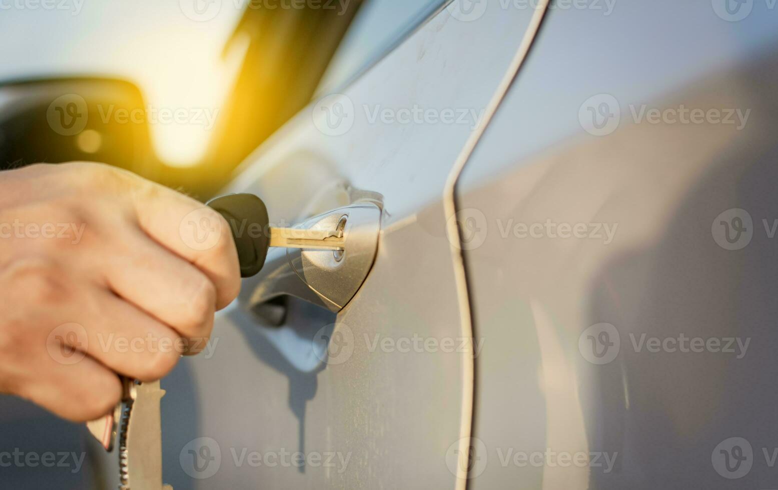Hands with keys opening the car door. Close-up of hands opening the car door with the key. Concept of hands with keys opening the car door. photo