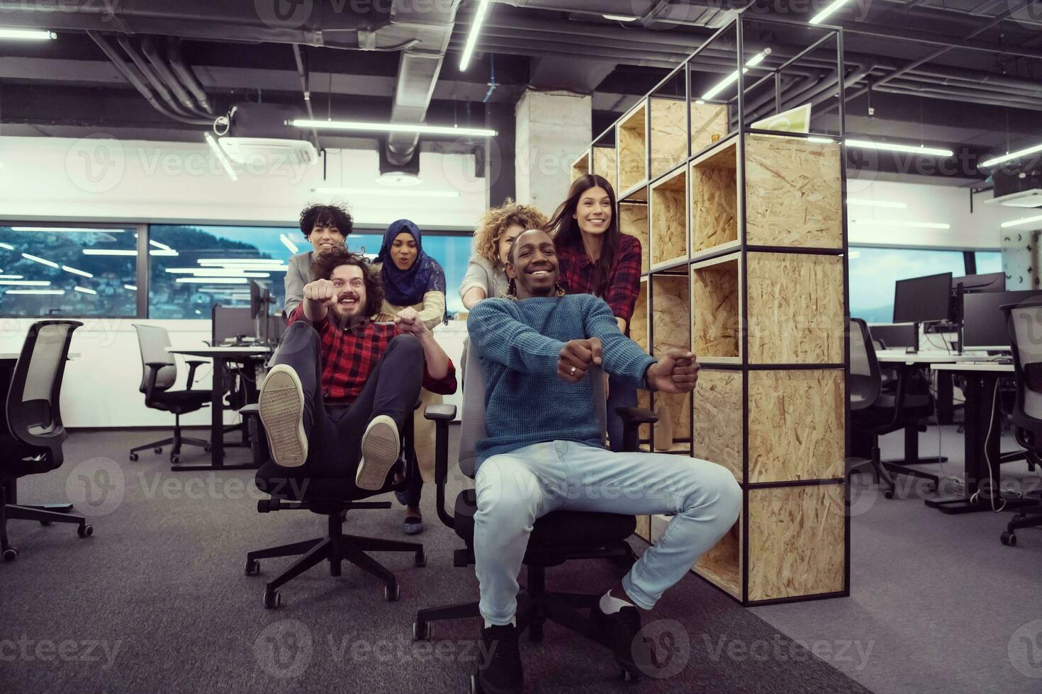 equipo de negocios multiétnico corriendo en sillas de oficina foto