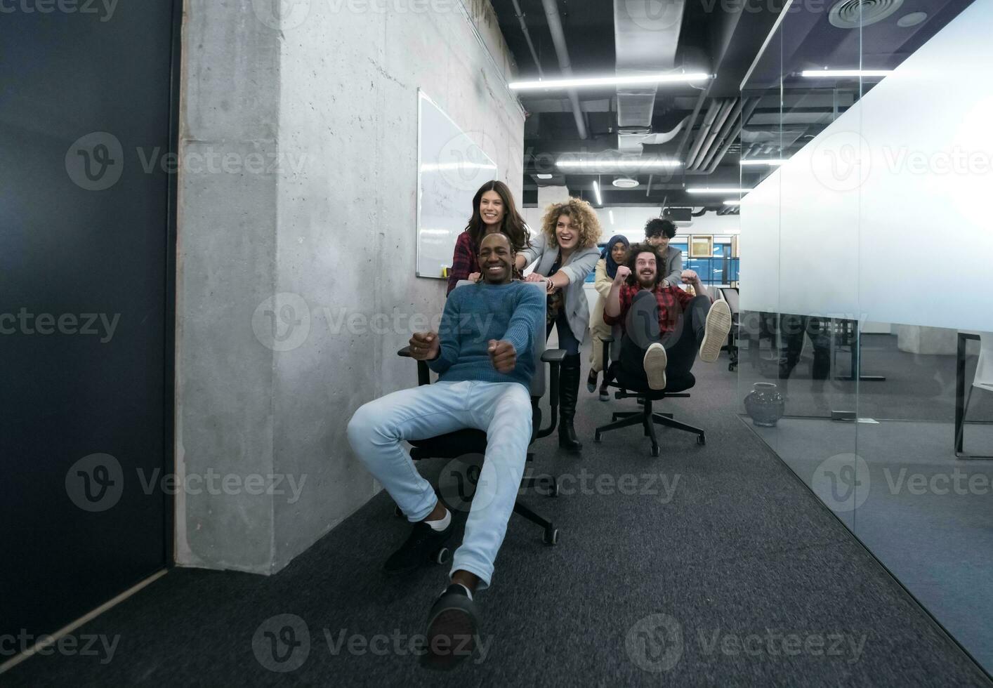 equipo de negocios multiétnico corriendo en sillas de oficina foto