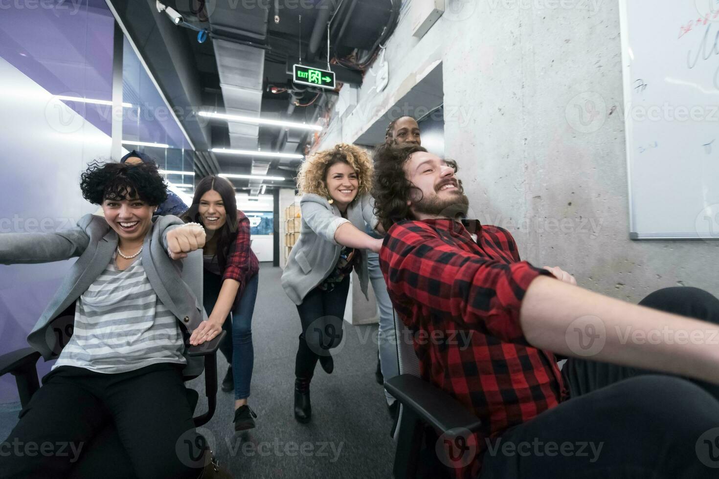 equipo de negocios multiétnico corriendo en sillas de oficina foto