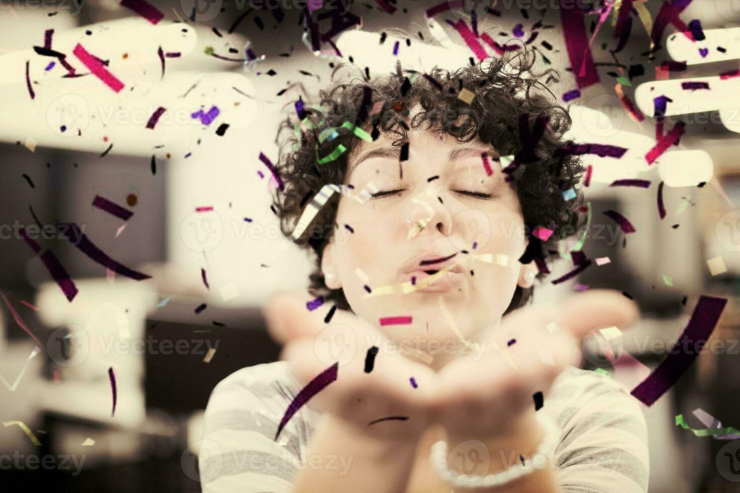 female software developer blowing confetti photo