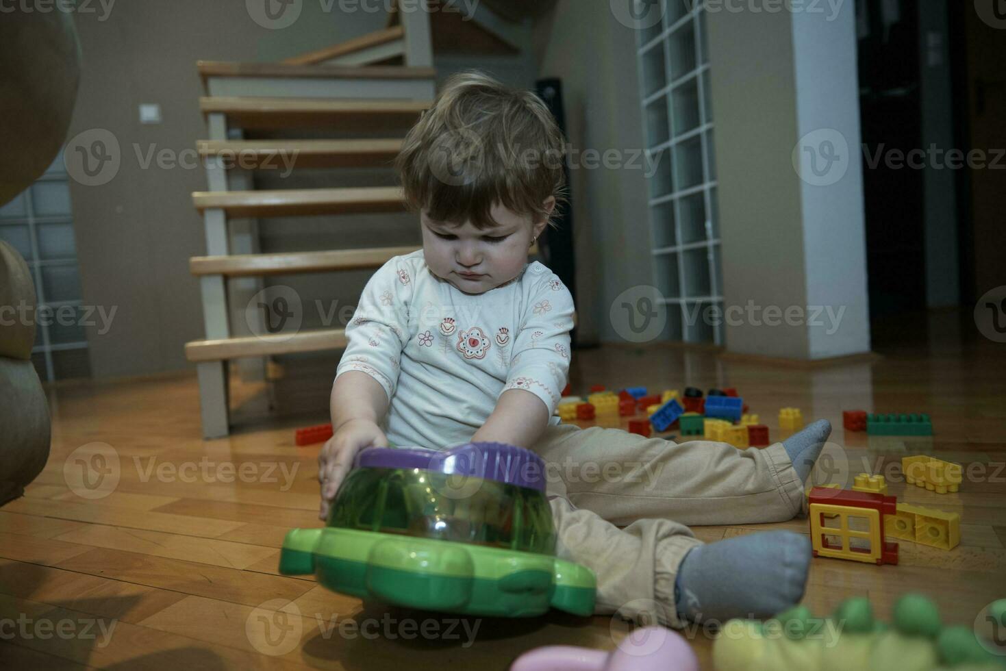 Adorable cute beautiful little baby girl playing with toys at home photo