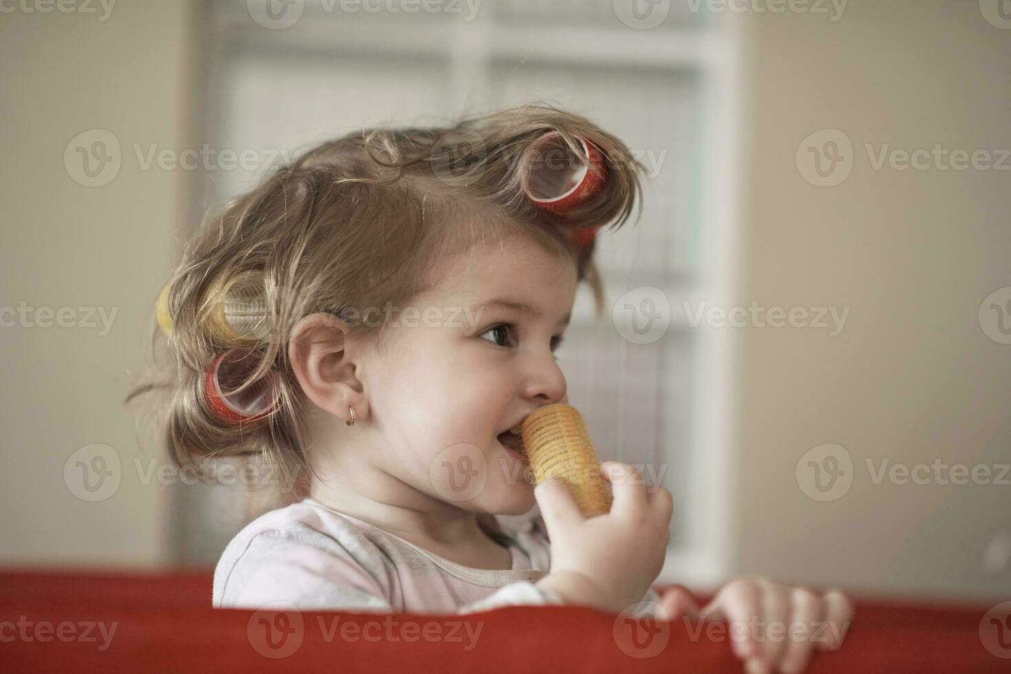 little baby girl with strange hairstyle and curlers photo