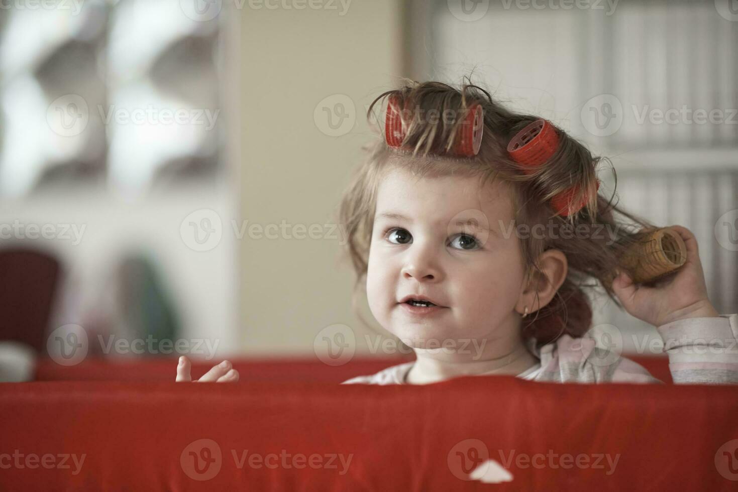 little baby girl with strange hairstyle and curlers photo