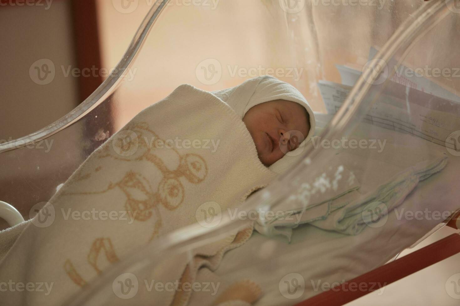 newborn baby sleeping in  bed at hospital photo