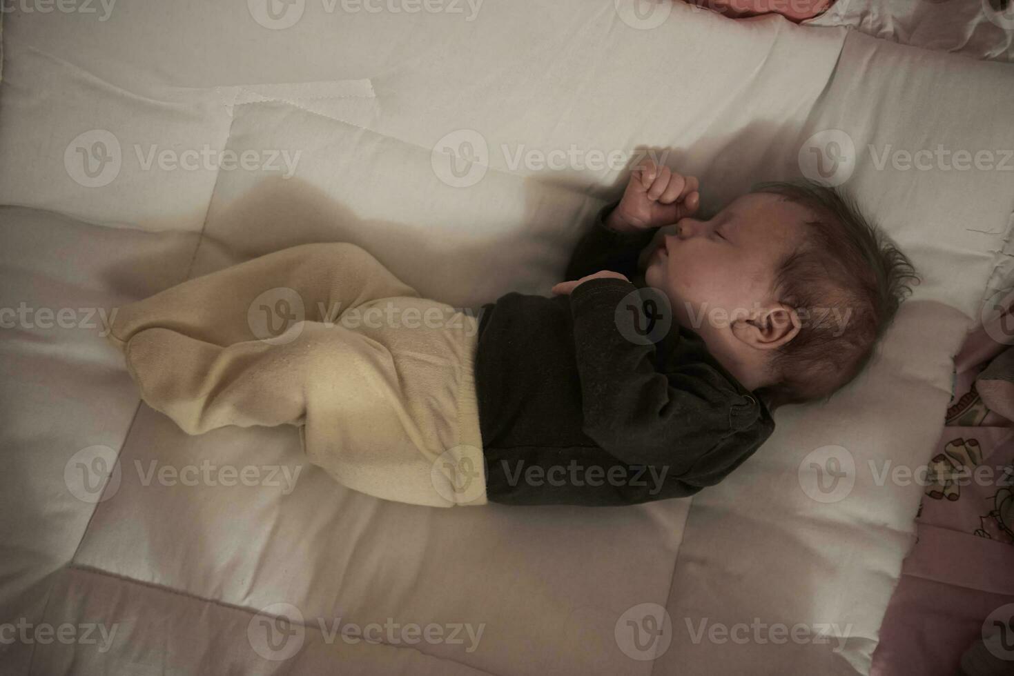 One month newborn baby sleeping  in bed photo