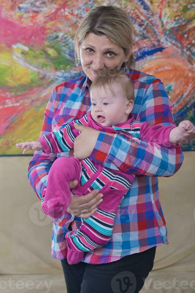 grandmother holding newborn baby at home photo