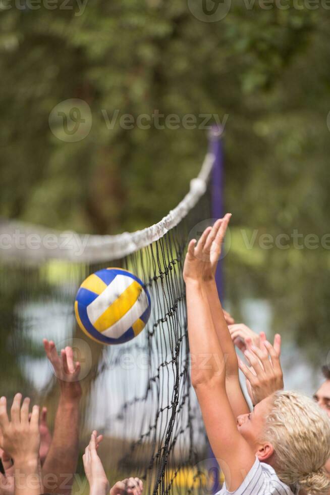 group of young friends playing Beach volleyball photo