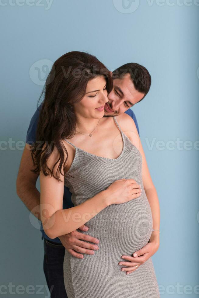 pregnant couple  isolated over blue background photo