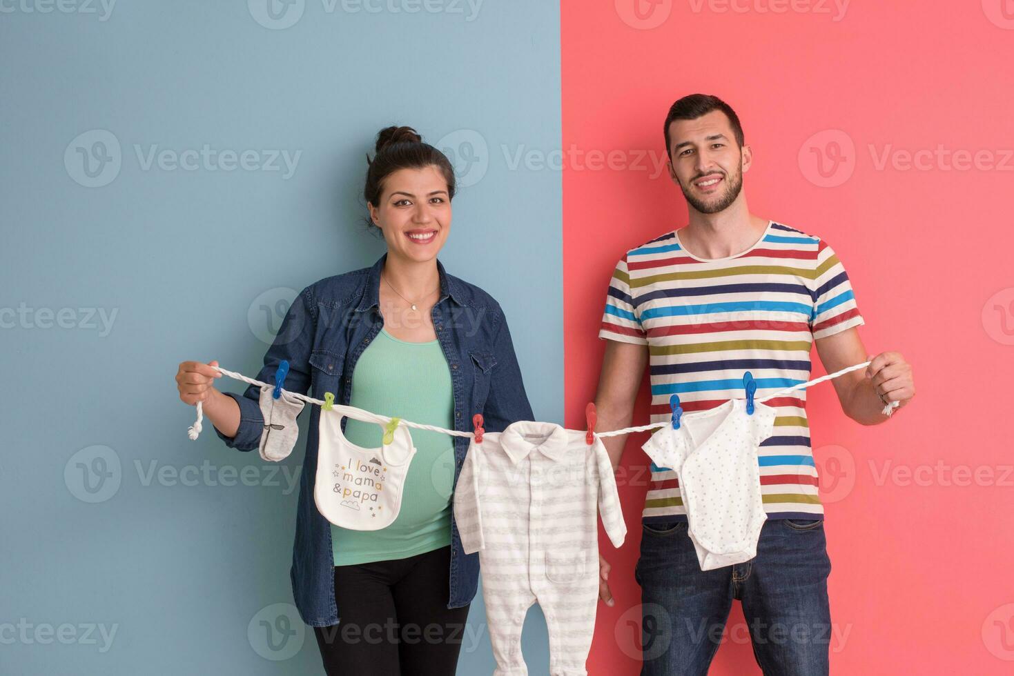young couple holding baby bodysuits photo