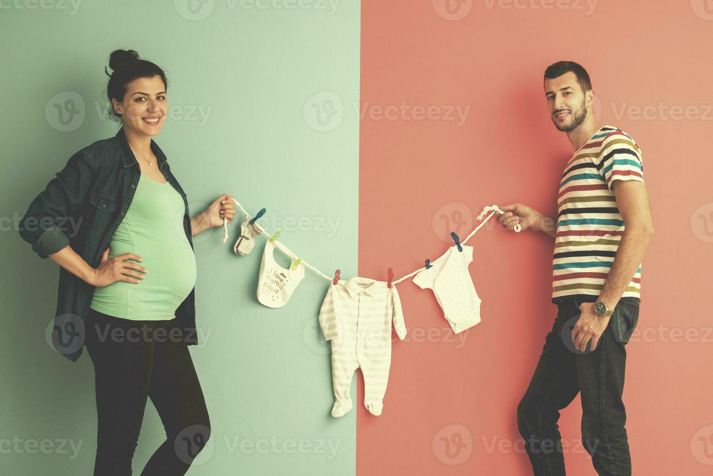 young couple holding baby bodysuits photo