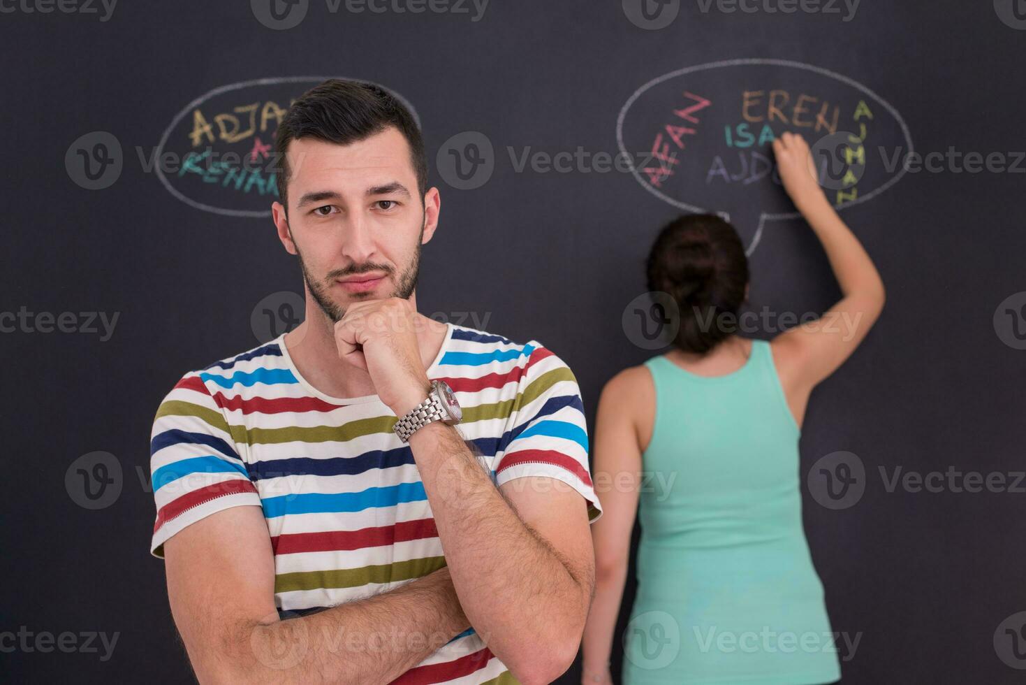 pregnant couple writing on a black chalkboard photo