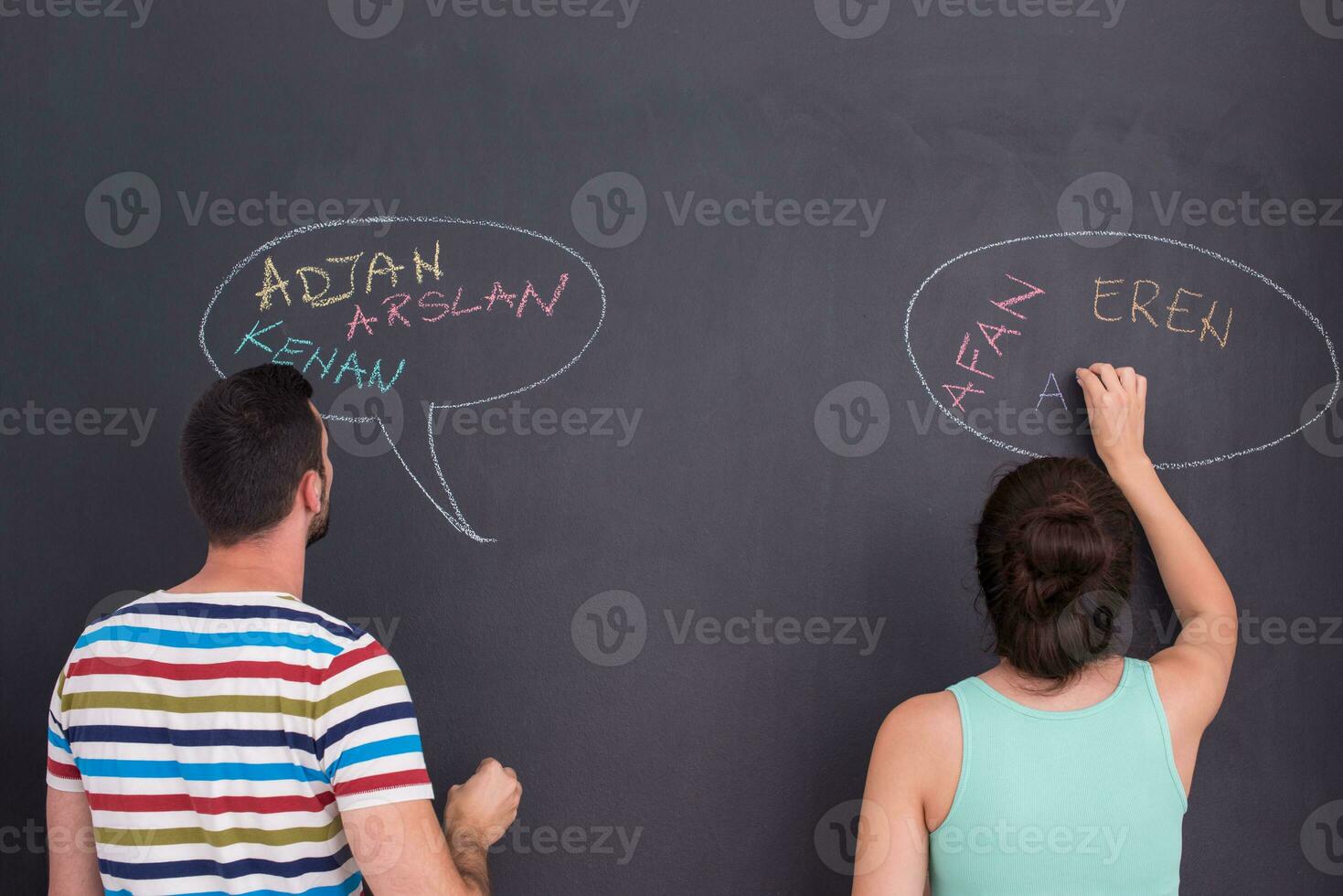 pregnant couple writing on a black chalkboard photo