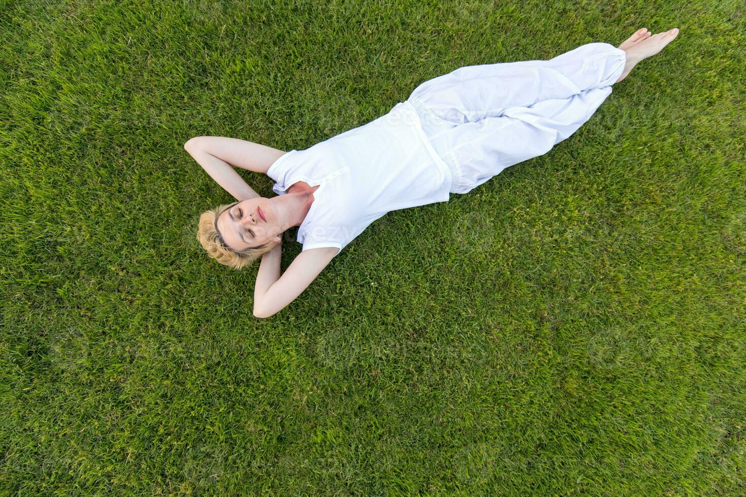 top view of young woman relaxing on the grass photo