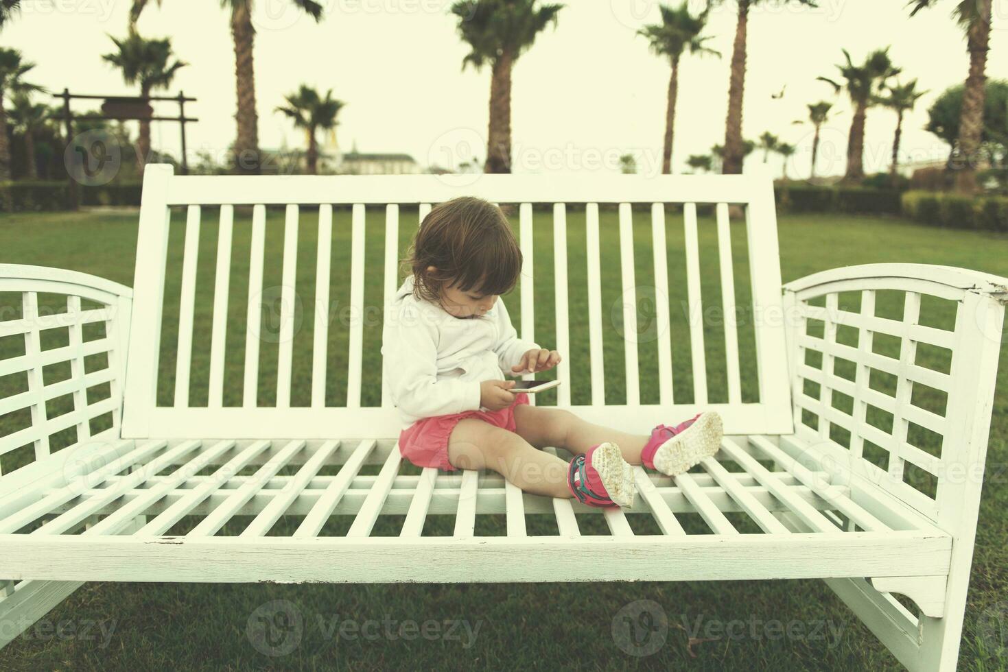 little girl playing with mobile phone photo