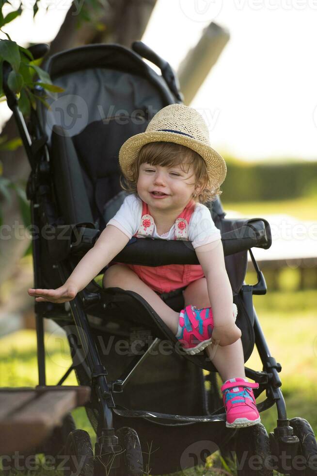 baby girl sitting in the baby stroller photo