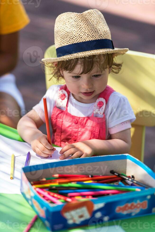 little girl drawing a colorful pictures photo