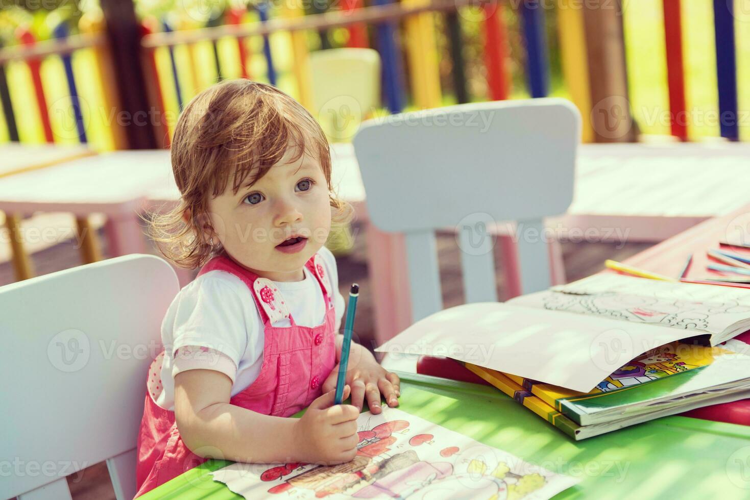 little girl drawing a colorful pictures photo