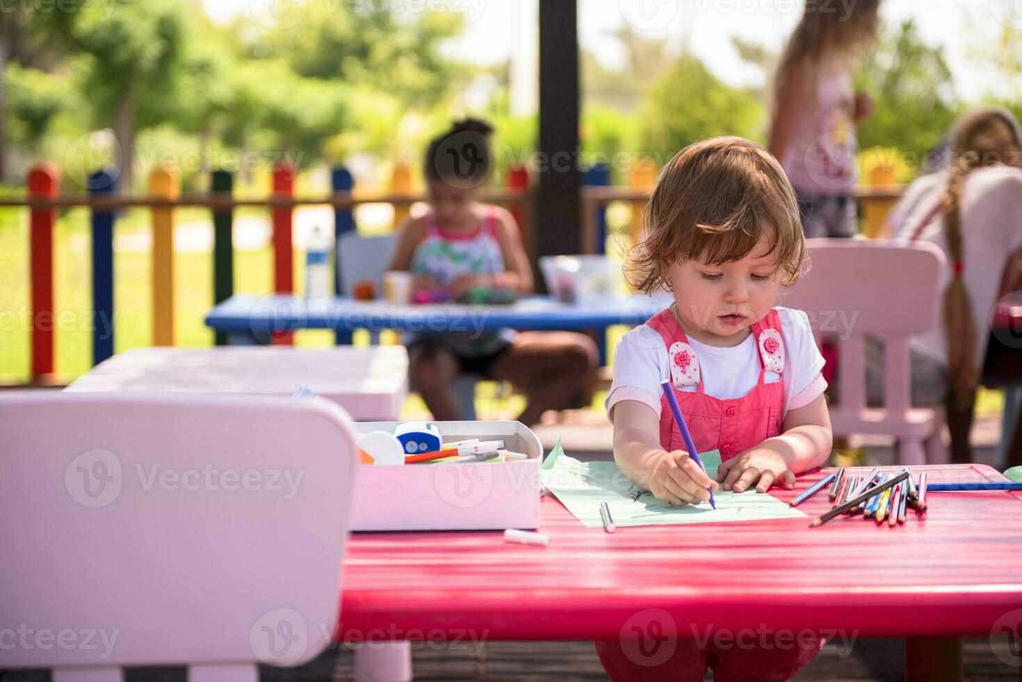 little girl drawing a colorful pictures photo