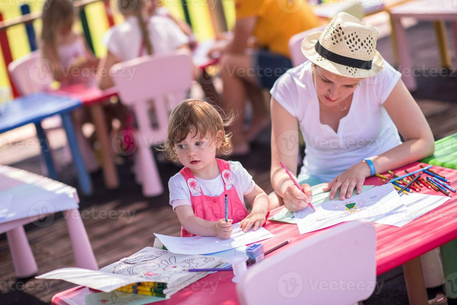 mamá y su pequeña hija dibujando imágenes coloridas foto