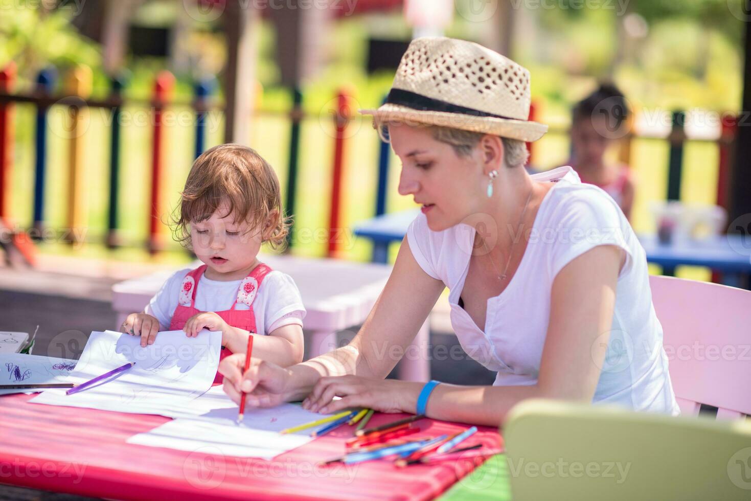 mamá y su pequeña hija dibujando imágenes coloridas foto