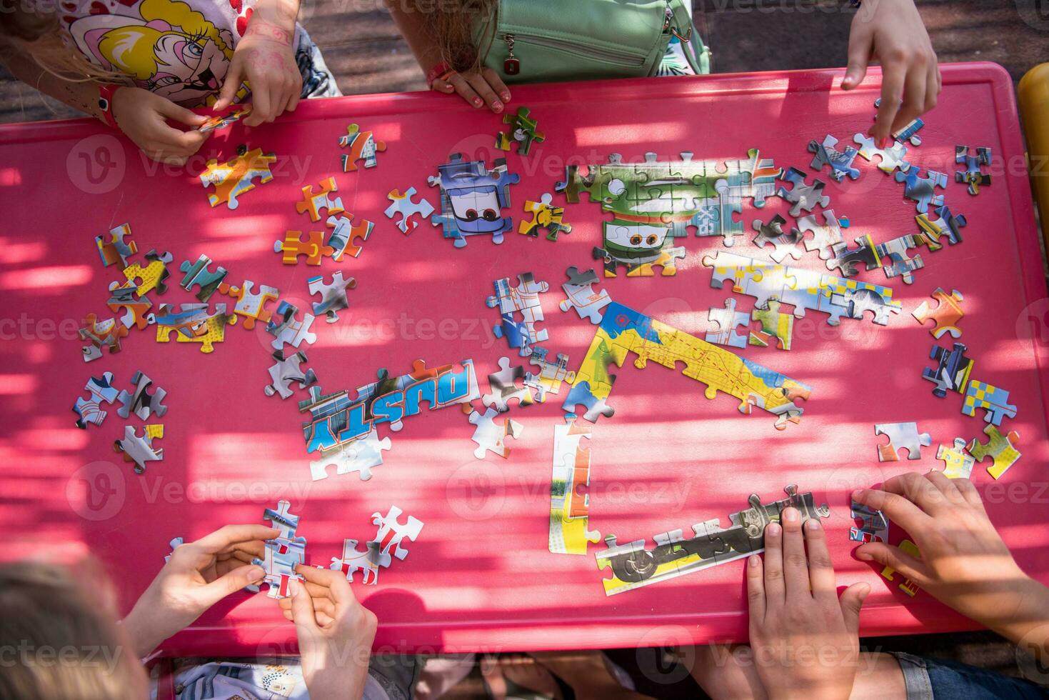 top view of kids hands playing with puzzles photo