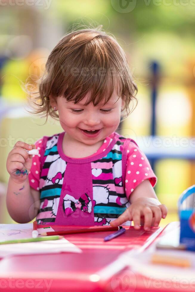 little girl drawing a colorful pictures photo