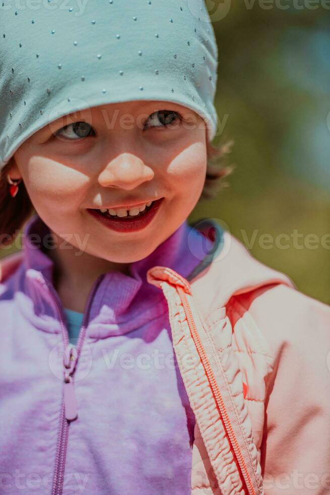 A little girl playing in the park. The concept of family socializing in the park. A girl swings on a swing, plays creative games photo