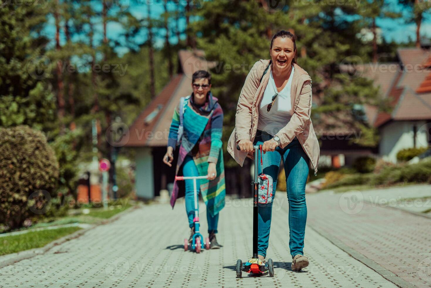 Two women having fun in the park while riding a scooter photo