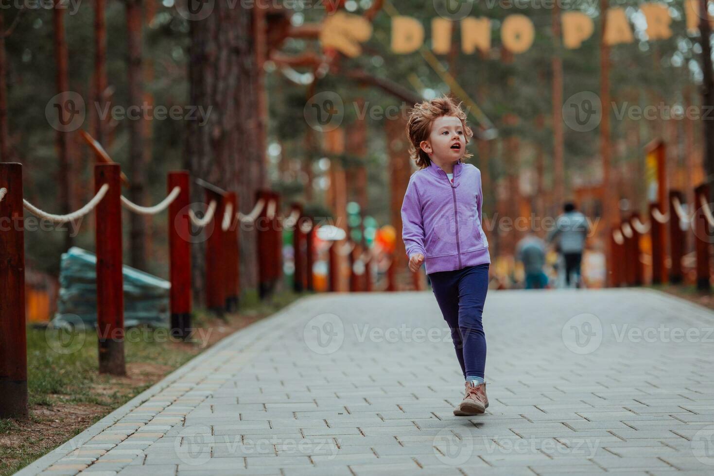 A little girl playing in the park. The concept of family socializing in the park. A girl swings on a swing, plays creative games photo