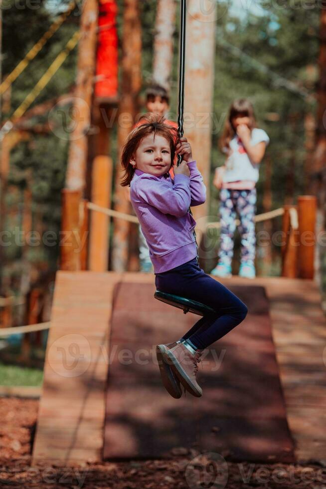 A little girl playing in the park. The concept of family socializing in the park. A girl swings on a swing, plays creative games photo