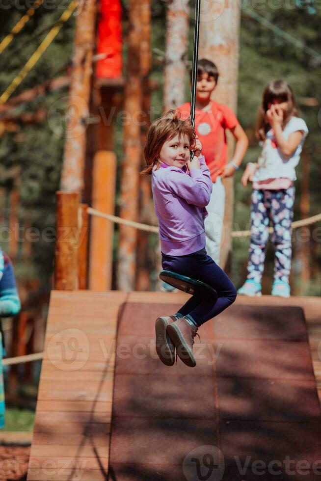 A little girl playing in the park. The concept of family socializing in the park. A girl swings on a swing, plays creative games photo