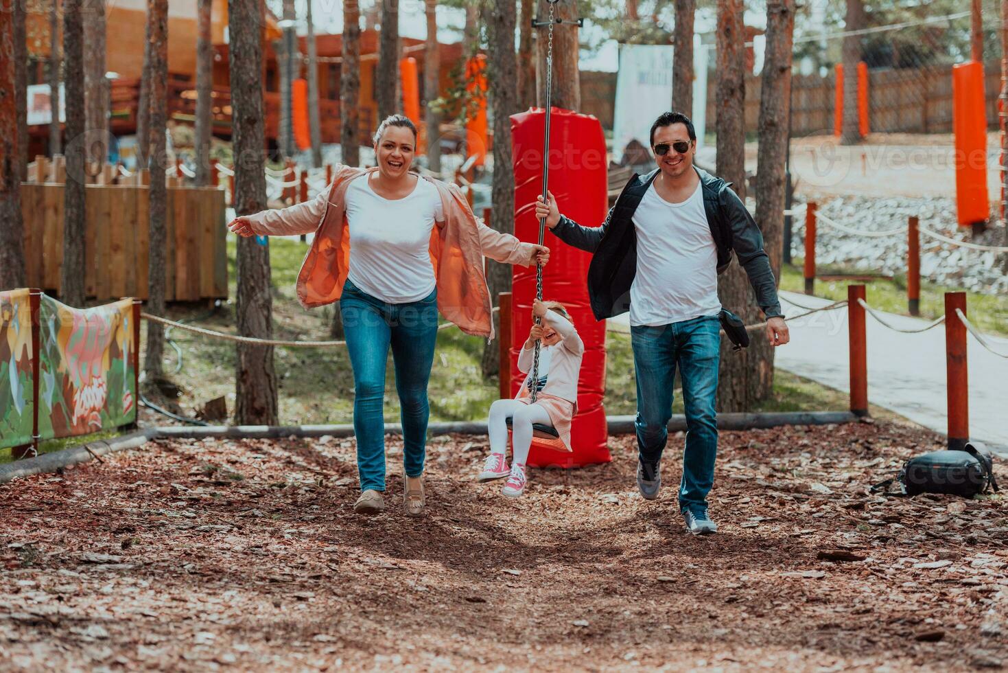 Family fun in the park. Happy family spending time in park and playing with their daughter photo