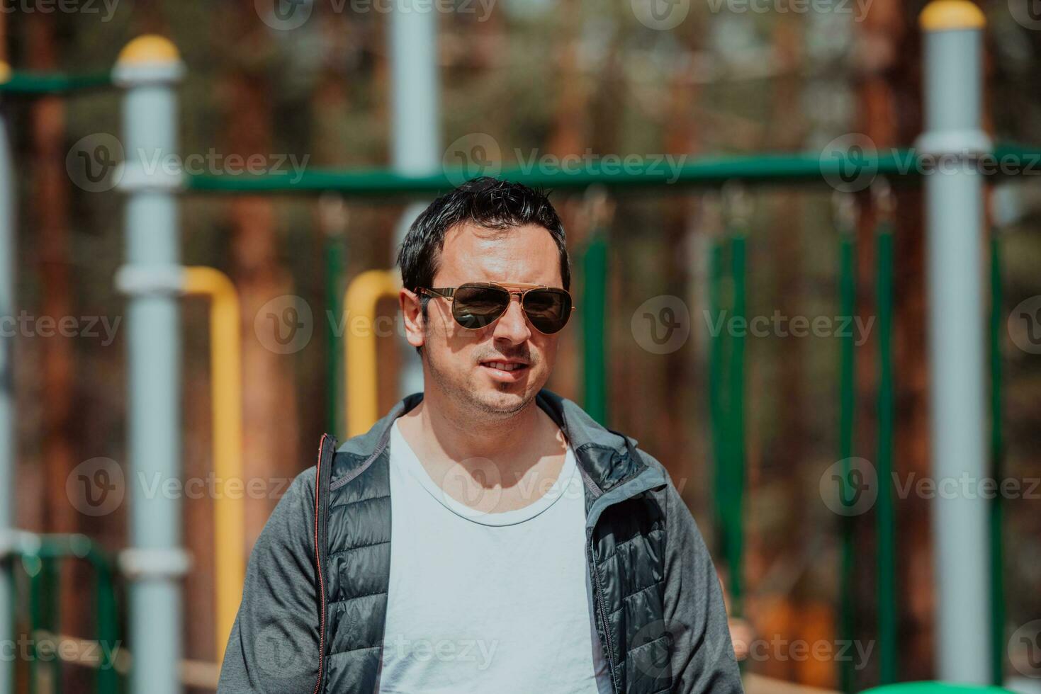 un moderno hombre con Gafas de sol gasto un soleado día en el parque foto