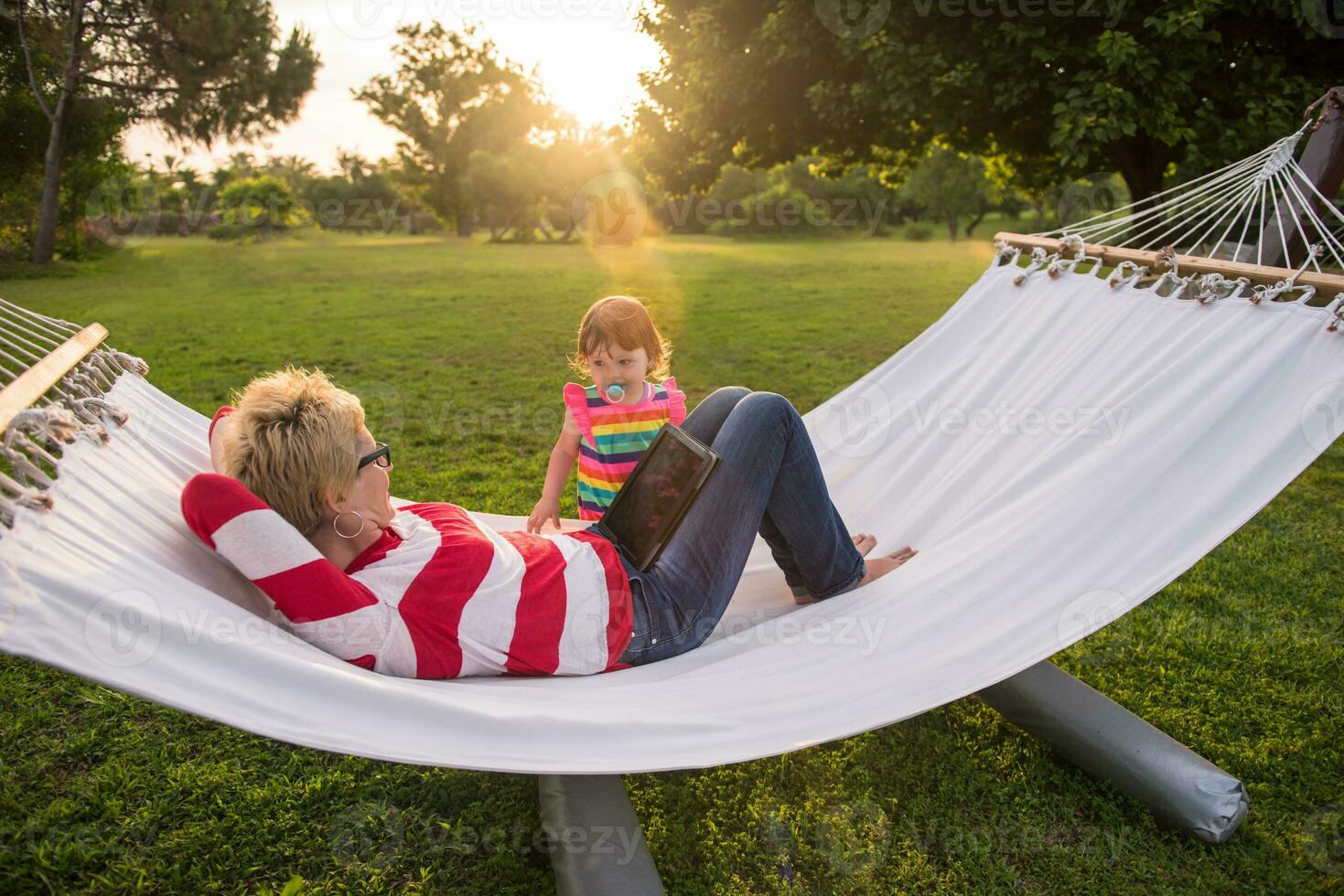 mom and a little daughter relaxing in a hammock photo